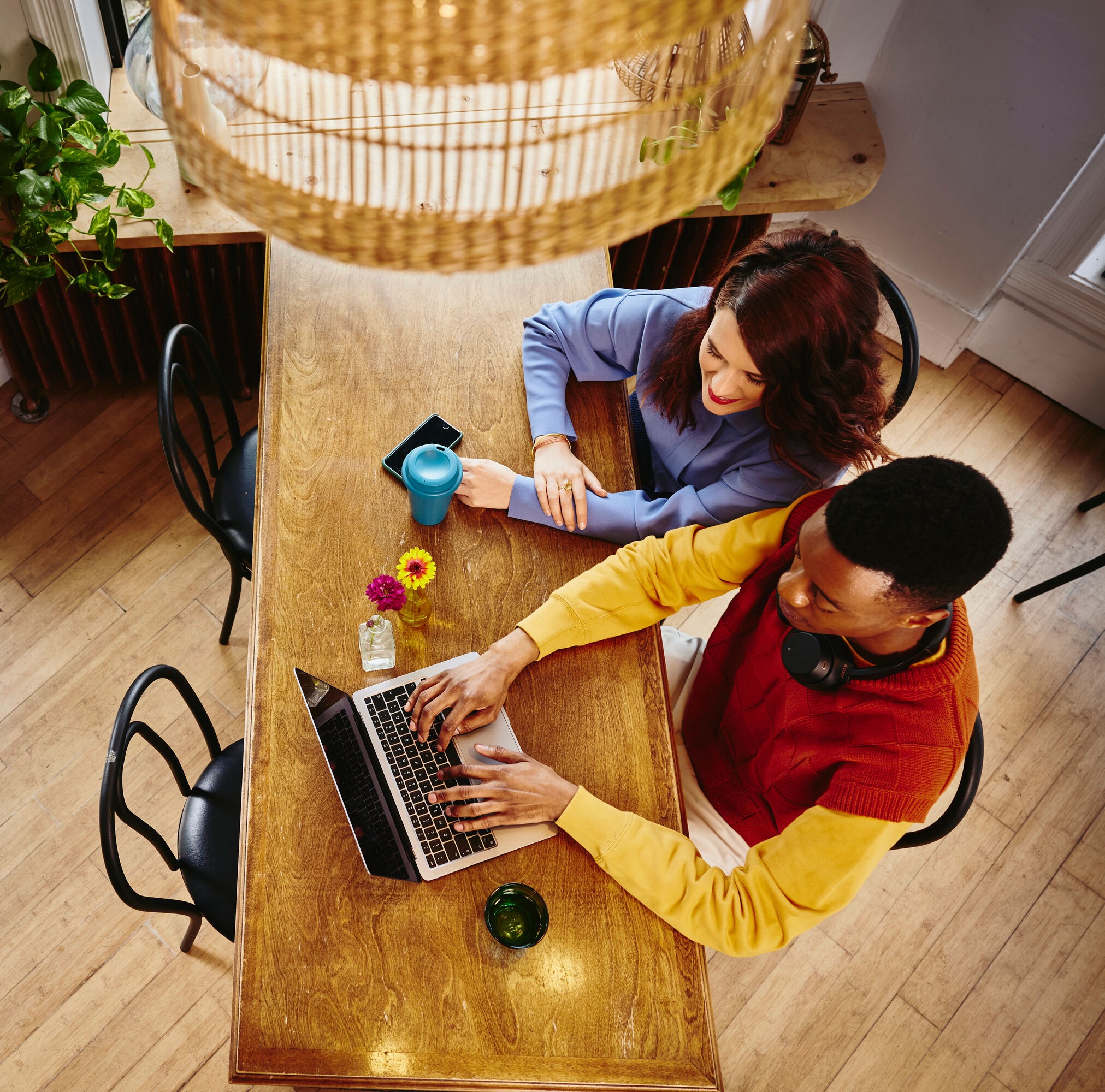 Bird view of a female and male working on a laptop at a table