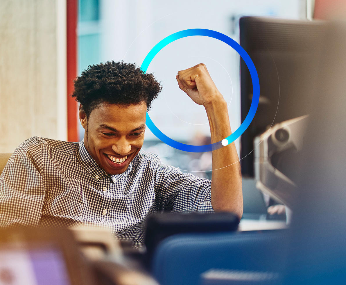 man cheering behind computer