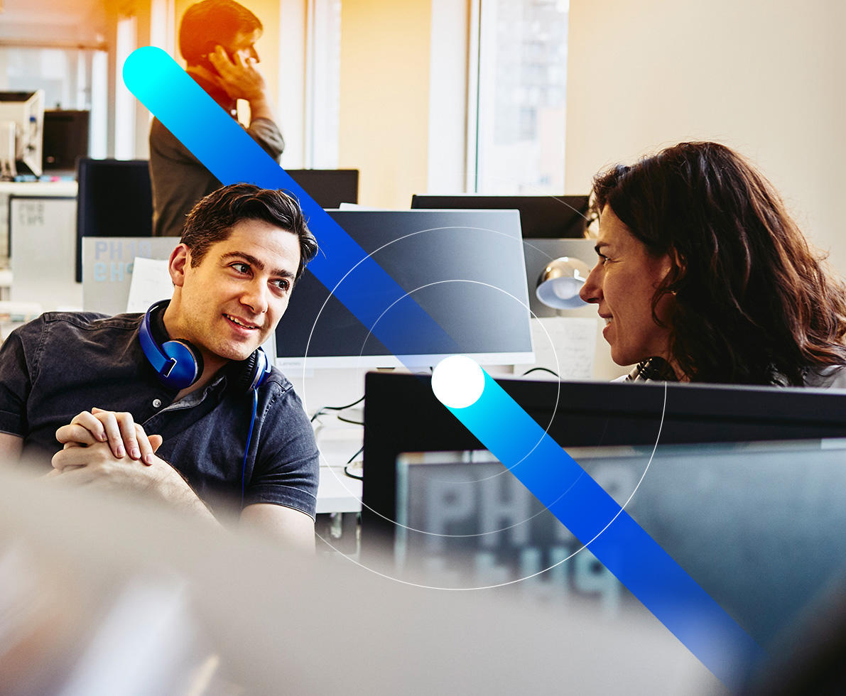 man and woman talking behind computer screen